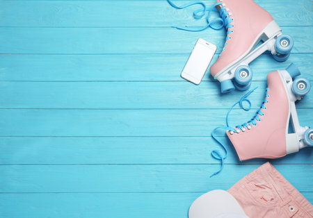 Flat lay composition with quad roller skates and space for text on wooden background