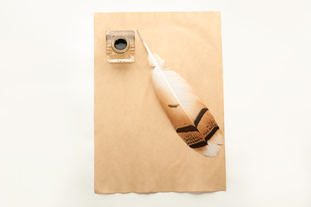 Feather pen, inkwell and sheet of paper on white background, top view. Space for textの写真素材