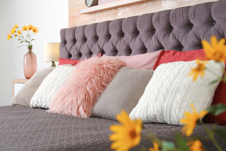 Different pillows on bed in room. Idea for interior decorの写真素材