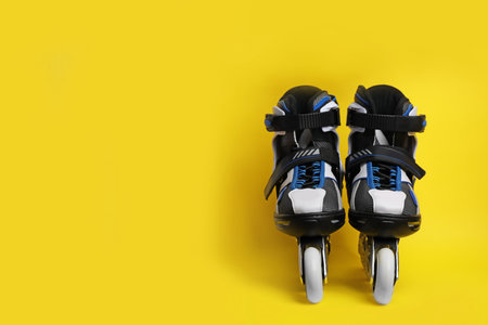 Pair of inline roller skates on color background. Space for text