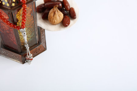 Muslim lamp, dates and prayer beads on white background. Space for textの写真素材