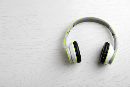 Stylish modern headphones and space for text on wooden background, top viewの写真素材