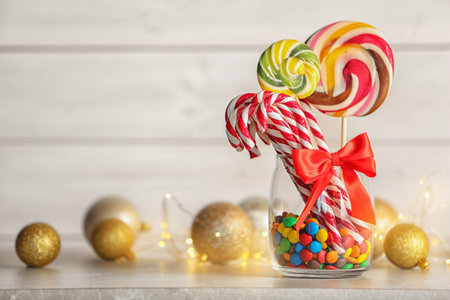 Different candies in glass jar for Christmas party on table. Space for textの写真素材