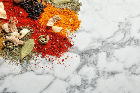 Different aromatic spices on marble background, top view with space for textの写真素材