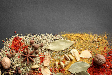 Different aromatic spices on dark background, top view with space for textの写真素材