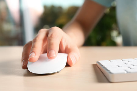 Woman using computer mouse and keyboard at table, closeupの写真素材