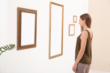 Young woman viewing exposition in modern art galleryの写真素材