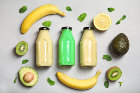 Flat lay composition with different smoothies in bottles and ingredients on color backgroundの写真素材