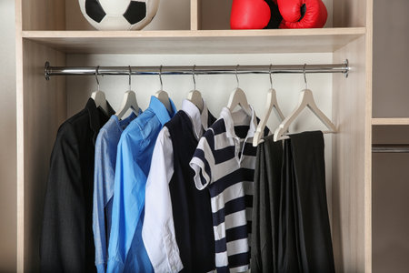 Wardrobe with stylish boy's clothes hanging on rackの写真素材