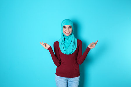 Portrait of young Muslim woman in hijab against color backgroundの写真素材