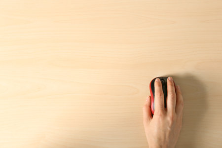 Woman using computer mouse on wooden background, top view. Space for textの写真素材