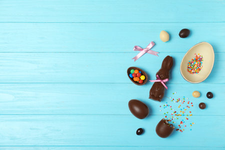 Flat lay composition with chocolate Easter eggs and space for text on wooden background
