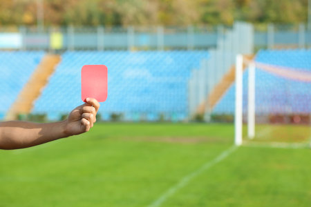 Football referee showing red card at stadium, closeup with space for textの写真素材