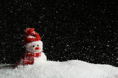 Decorative snowman on black background, space for text. Winter weatherの写真素材