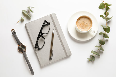 Flat lay composition with notebook, cup of coffee and wrist watch on white background