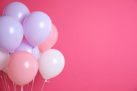 Colorful party balloons on pink background. Space for textの写真素材