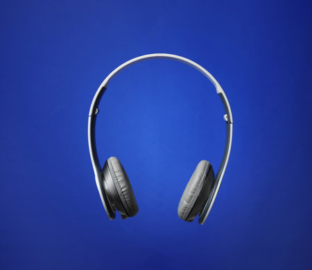Stylish modern headphones with earmuffs on color backgroundの写真素材
