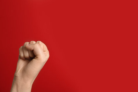Woman raising her fist and space for text on color background. Victory conceptの写真素材