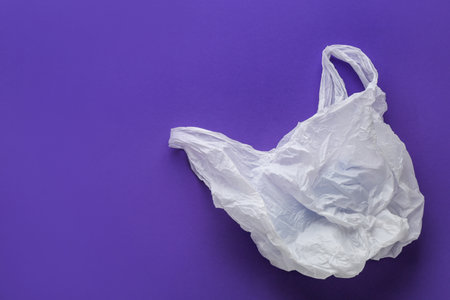 Clear disposable plastic bag on color background. Space for text