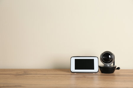 Baby monitors on wooden table, space for text. CCTV equipment