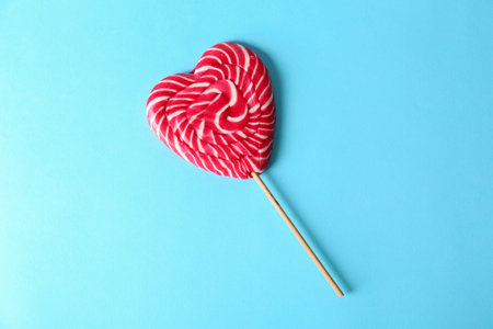 Heart shaped lollipop on color background, top view. sweet loveの写真素材