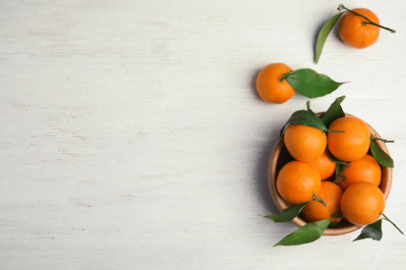 Flat lay composition with fresh ripe tangerines and space for text on wooden backgroundの写真素材