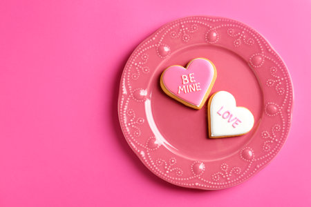 Plate with decorated heart shaped cookies and space for text on color background, top view. Valentine's day treatの写真素材