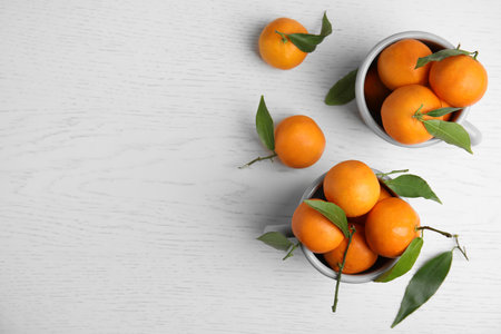 Flat lay composition with fresh ripe tangerines and space for text on wooden backgroundの写真素材