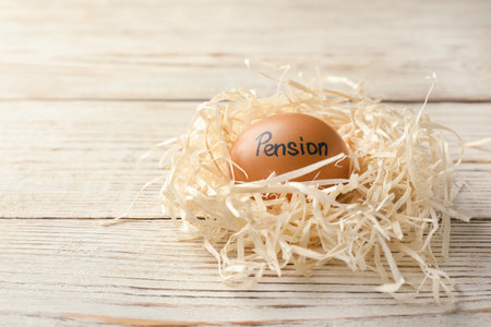 Egg with word PENSION in nest on wooden background. Space for textの写真素材