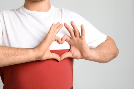 Man making heart with his hands on light background, closeupの写真素材