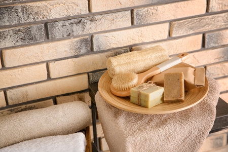 Plate with brush, wisp and handmade soap bars on table. Space for textの写真素材