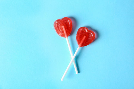 Heart shaped lollipops on color background, top view. sweet loveの写真素材