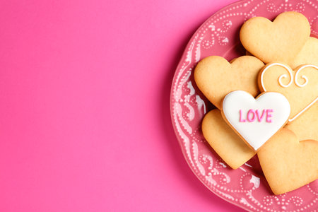 Plate with decorated heart shaped cookies and space for text on color background, top view. Valentine's day treatの写真素材