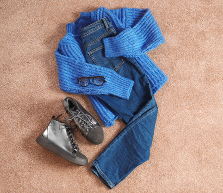 Flat lay composition with jeans, sweater and shoes on color fabricの写真素材