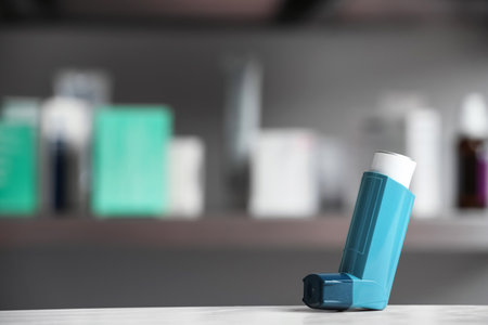Asthma inhaler on table against blurred background. Space for textの写真素材