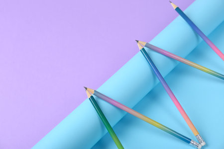 Composition with pencils and rolled paper on color background. Space for textの写真素材