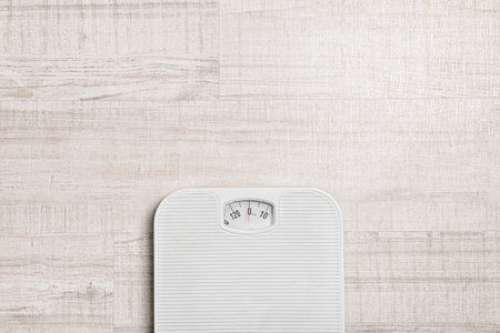Bathroom scales and space for text on wooden background, top view. weight loss concept