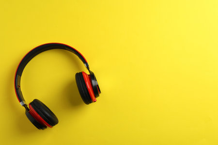 Wireless headphones on color background, top view. Space for textの写真素材