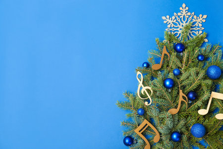 Flat lay composition with fir tree, Christmas decor and wooden music notes on color background. Space for textの写真素材