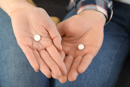 Man and woman holding pills, closeup viewの写真素材