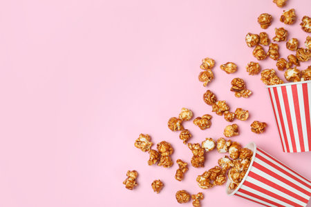 Overturned paper cups with caramel popcorn on color background, top view. Space for textの写真素材