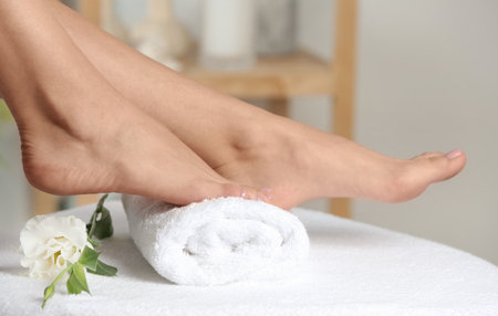 Woman with smooth feet on white towel indoors, closeup. spa treatmentの写真素材