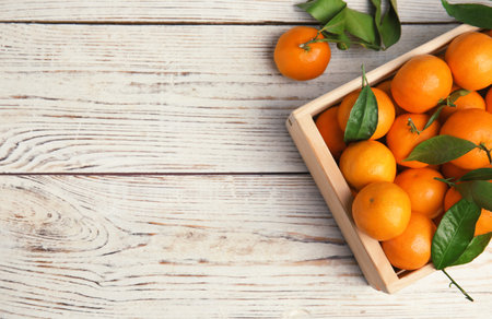 Crate with fresh ripe tangerines and space for text on wooden background, top viewの写真素材