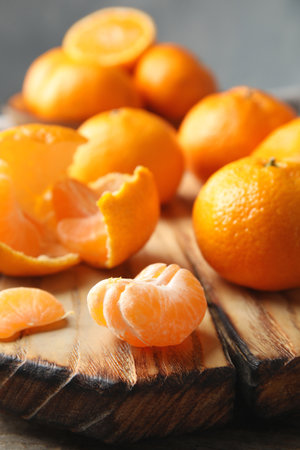Wooden board with ripe tangerines on tableの写真素材