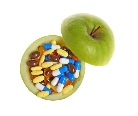 Cut apple full of weight loss pills on white background, top viewの写真素材