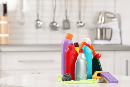 Set of cleaning supplies on table in kitchen. Space for textの写真素材