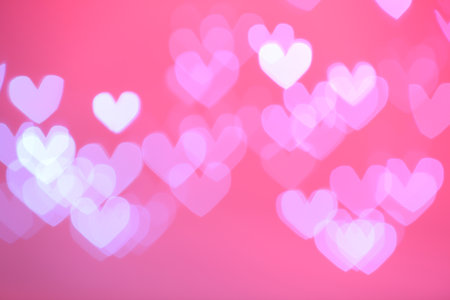 Blurred view of beautiful heart shaped lights on color backgroundの写真素材