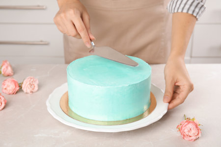 Woman making fresh delicious birthday cake in kitchen, closeupの写真素材