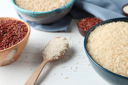 Composition with brown and other types of rice on white wooden backgroundの写真素材