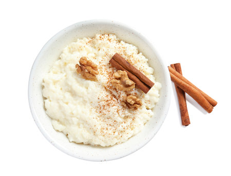 Creamy rice pudding with cinnamon and walnuts in bowl on white background, top viewの写真素材